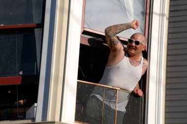 Tattooed guy in window along Dyke March route